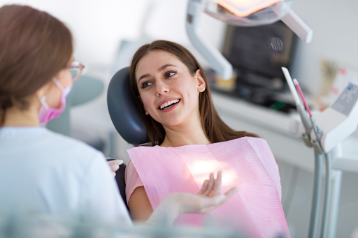 Smiling woman sitting in a dentist's chair and talking to a dentist