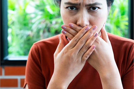 A woman covering her mouth with her hands.