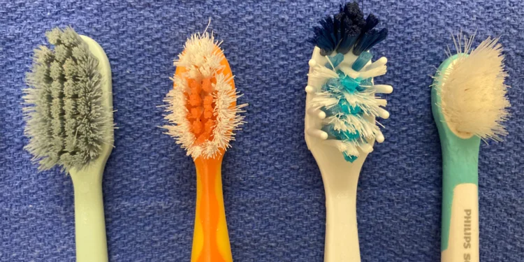 A picture of 4 toothbrushes with worn out bristles