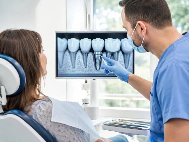 A picture of a dentist demonstrating a 3d scan of the patient's teeth